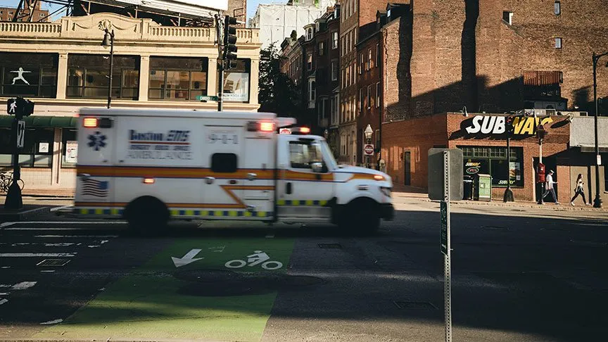 An ambulance enroute to an emergency call, traveling down a city street.