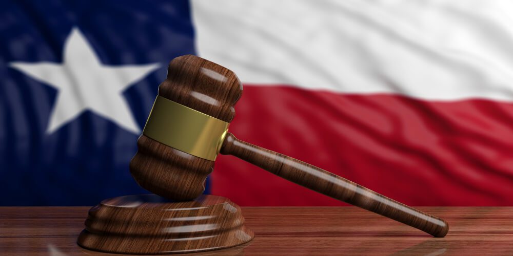 Judge or auction gavel on Texas US of America waving flag background.