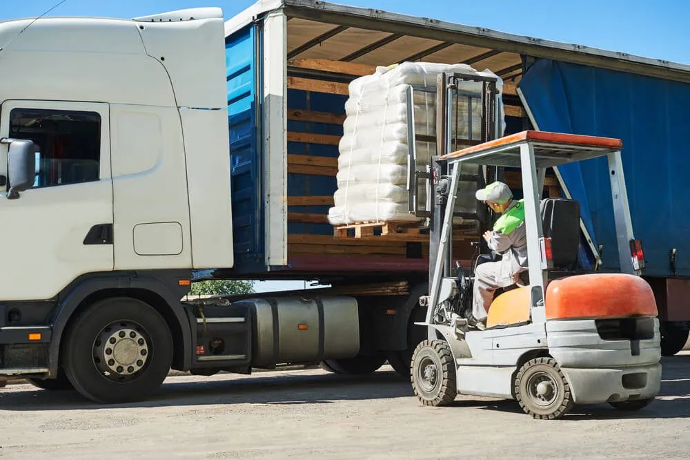 Loading works. Forklift with load and lorry truck