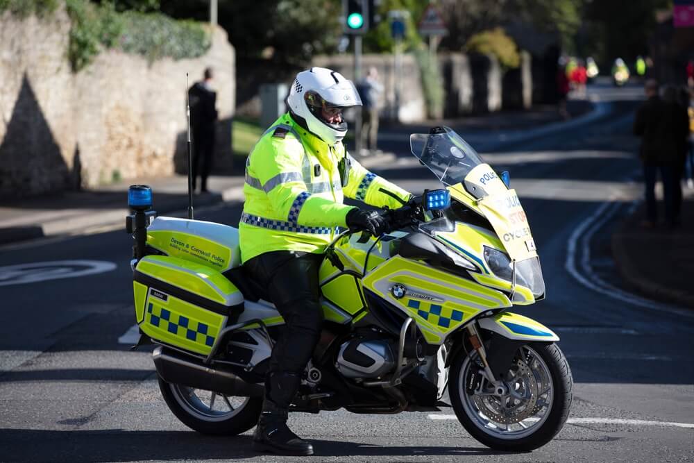 Police motorbike rider blocks a road