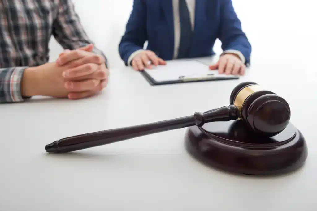 Client and lawyer sitting at a table, discussing documents.