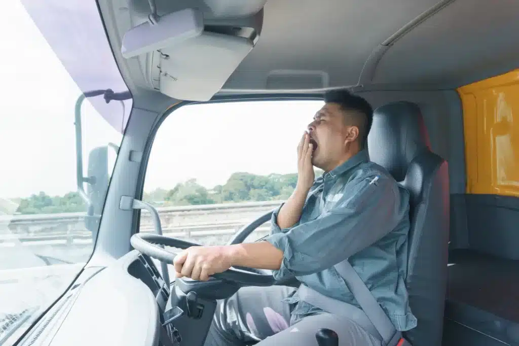 A commercial driver yawning while driving.