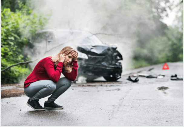 A person on the phone with emergency services after being in a car accident.