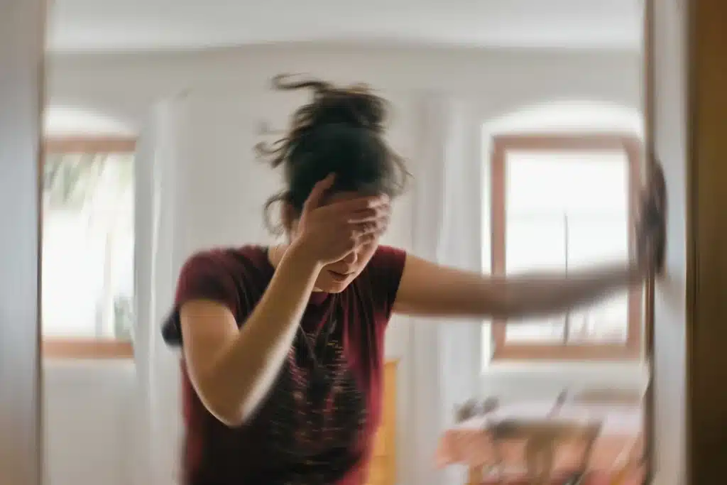 A person feeling dizzy, holding their head.
